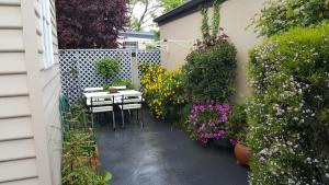 mały ogród ze stołem i kwiatami w obiekcie Arendon Cottage w mieście Evandale