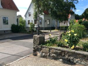 a street with two houses and a stone wall at Pia's Apartment in Gothenburg