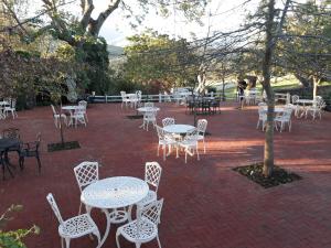 a group of tables and chairs on a brick patio at Eight Bells Mountain Inn in Ruiterbos