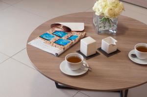 a table with a cake and two cups of coffee at Blubay Apartments by ST Hotels in Il-Gżira