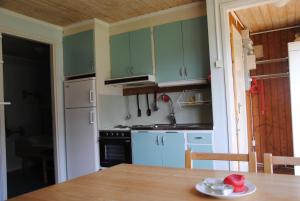 uma cozinha com armários verdes e uma mesa de madeira em Bydalens Fjällby em Hallen