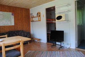 a living room with a table and a television at Bydalens Fjällby in Hallen
