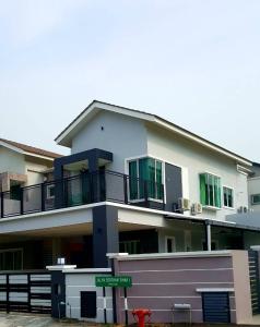 a large white building with green windows and a red fire hydrant at Ipoh EastEden Homestay in Ipoh