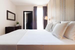 a large white bed with white pillows in a room at Blubay Apartments by ST Hotels in Il-Gżira +28 photos