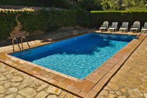 einen Pool mit Stühlen im Hof in der Unterkunft Casa Rural Arroyo Rechita in La Iruela