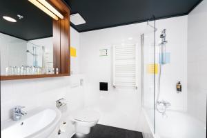 a bathroom with a sink, toilet, and bathtub at Bo18 Hotel Superior in Budapest