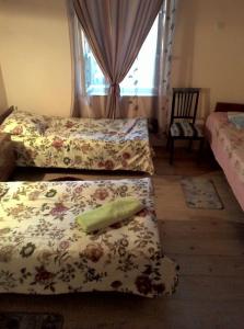 a bedroom with three beds and a window at Guest House Gabo in Mestia