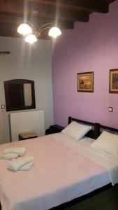 a bedroom with a large bed with two towels on it at Guesthouse Oneiro in Kato Loutraki