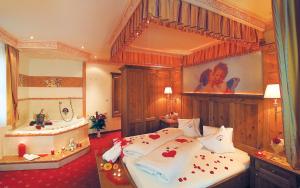 a bedroom with a large bed and a tub at ... mein romantisches Hotel Toalstock in Fiss