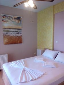 a bedroom with a white bed with a painting on the wall at Rafina Port Paradise in Rafina