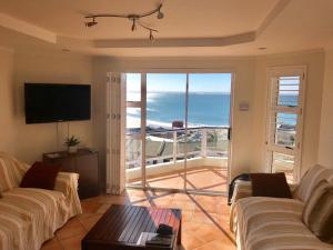 ポートエリザベスにあるBrookes Hill Executive Apartmentのソファ付きのリビングルームが備わり、海の景色を望めます。