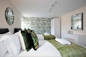 a white bedroom with two beds and a mirror at The Old Bank - Your Apartment in Bristol