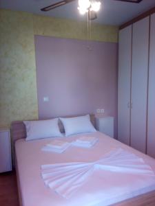 a bedroom with a white bed with two towels on it at Rafina Port Paradise in Rafina