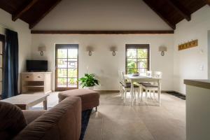 a living room with a couch and a table and chairs at Pension Kleiner König in Struppen-Siedlung