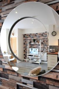 a circular mirror on a brick wall in a living room at The Old Bank - Your Apartment in Bristol