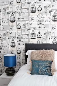 a bedroom with a black and white wall with a bird cage wallpaper at The Old Bank - Your Apartment in Bristol