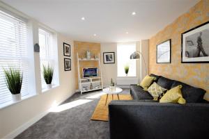 a living room with a couch and some windows at The Old Bank - Your Apartment in Bristol