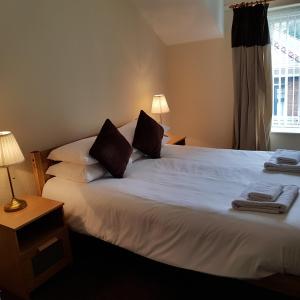 a bedroom with a large white bed with two pillows at Ty Morgan's Apartments in Rhayader