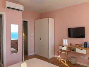 a bedroom with a white cabinet and a television at Ai Pesci Room Rental in Riomaggiore