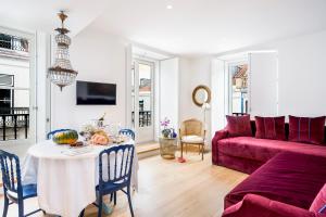 a living room with a table and a red couch at Residentas Aurea in Lisbon