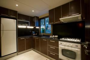 a kitchen with brown cabinets and a white appliance at Lahoya Garden in Beirut
