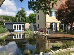 a garden with a pond in front of a house at Pure Nature Munich - Amper Meadows/Freising in Haag an der Amper
