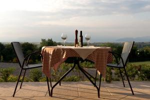 ポンティ・スル・ミンチョにあるagriturismo2laghiのワイングラス2杯と椅子2脚付きのテーブル