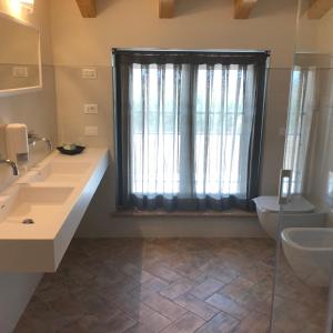 a bathroom with two sinks and a large window at agriturismo2laghi in Ponti Sul Mincio