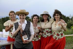a group of people posing with a bottle of wine at agriturismo2laghi in Ponti Sul Mincio +3 photos