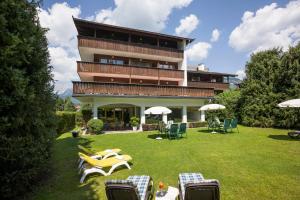 ein Gebäude mit Stühlen und Tischen im Hof in der Unterkunft Sporthotel Austria in Sankt Johann in Tirol