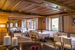 a restaurant with tables and chairs in a room at Sporthotel Austria in Sankt Johann in Tirol