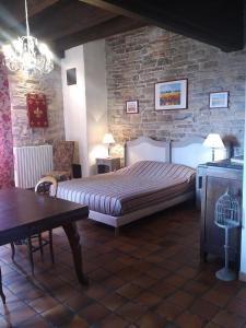 um quarto com uma cama e uma parede de pedra em Auberge de La Halle em Cordes-sur-Ciel