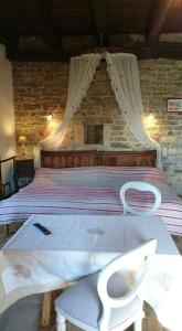 - une chambre avec un grand lit et une chaise blanche dans l'établissement Auberge de La Halle, à Cordes-sur-Ciel 40 autres photos