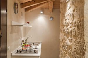 a kitchen with a sink and a stove in a room at Sunset Studio in Scicli