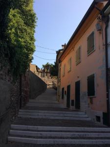 un callejón en un casco antiguo con escaleras empinadas en Locazione turistica Isabella en Castelnuovo del Garda