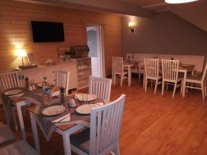 a dining room with a table and chairs and a television at Guest House Carpathia in Vişeu de Sus