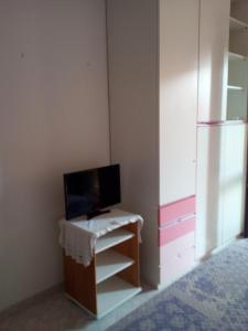 クアルトゥッチュにあるBed and Breakfast Il Soleのデスク、テレビ、冷蔵庫が備わる客室です。
