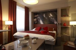 a hotel room with a bed and a table at Aparthotel Adagio Vienna City in Vienna