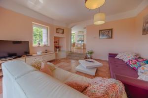 a living room with a couch and a tv at Apartments Melanie in Opatija