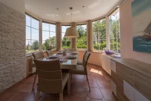 a dining room with a table and chairs and windows at Apartments Melanie in Opatija