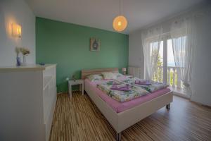 a bedroom with a bed and a green wall at Apartments Melanie in Opatija +127 photos