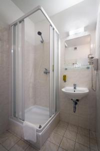 a bathroom with a shower and a sink at Hotel Aida in Prague