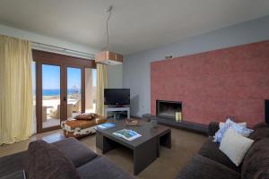 a living room with a couch and a fireplace at Alav Pool Villa in Afantou