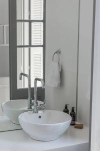 a bathroom with a white sink and a mirror at Kumba in Chania