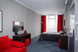 ブリャンスクにあるRaketa hotelのベッドルーム(赤いベッド1台、赤いソファ付)