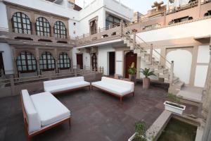 an apartment patio with white furniture and stairs at Guleria Kothi at Ganges in Varanasi