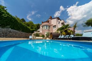 a large swimming pool in front of a house at Apartments Melanie in Opatija