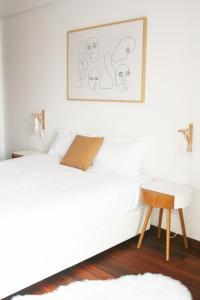 アヴェイロにあるGare Do Solの白いベッドルーム(白いベッド1台、テーブル付)