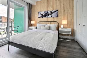 a bedroom with a bed and two tables and a window at INITIAL - PILOTE - Centre-Ville de Québec in Quebec City +20 photos
