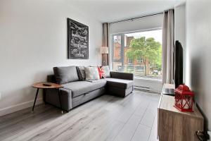 a living room with a couch and a window at INITIAL - PILOTE - Centre-Ville de Québec in Quebec City